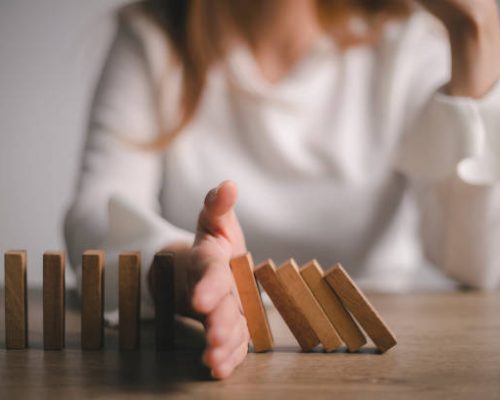 Risk and Strategy in Business, Hand stopping wooden block domino business crisis effect or risk protection concept, prevention and development to stability